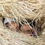 Die Kinder spielen Verstecken im Heu